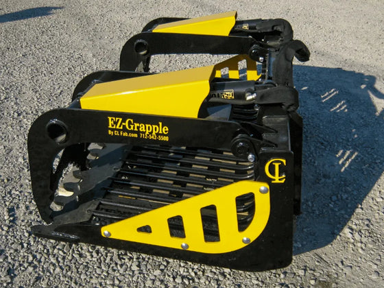 A yellow and black EZ-Grapple bucket attachment sitting on a gravel road