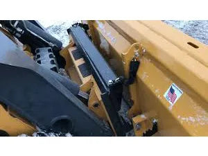 The snow plow is angled and appears to be made of heavy-duty steel.